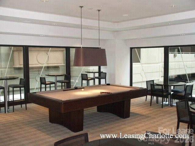 230 South Tryon Street, Unit 1002 Charlotte, NC 28202 - Photo 16 of 19 a dining hall with couches a dining table and chairs with wooden floor