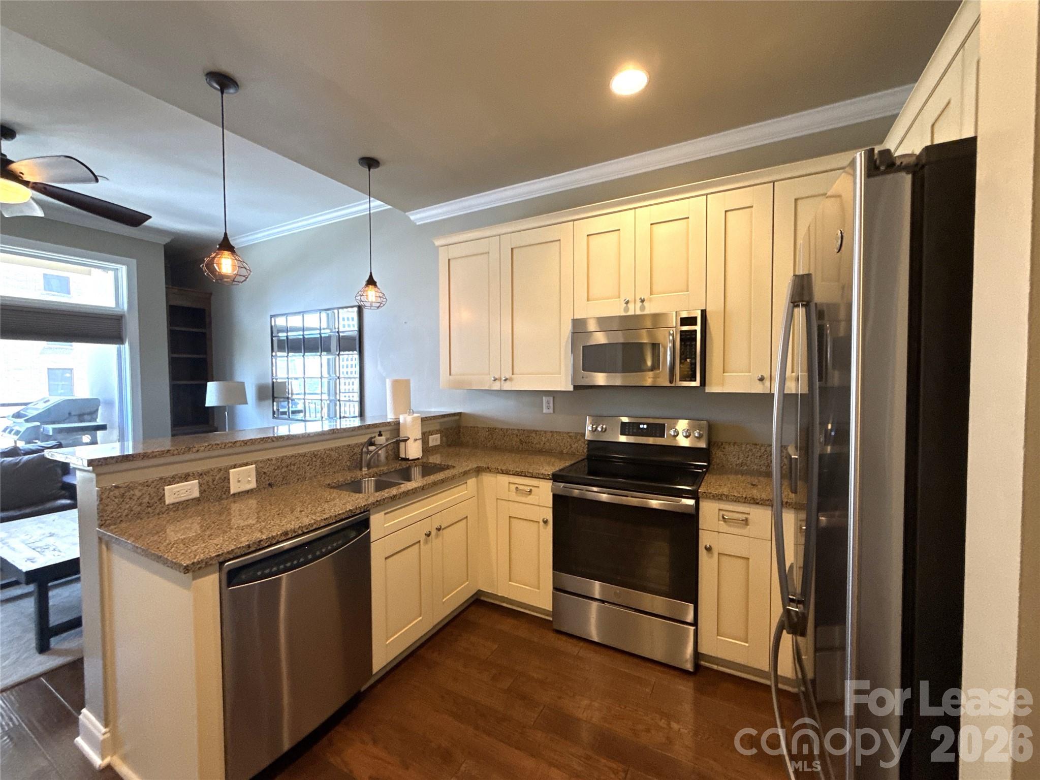 230 South Tryon Street, Unit 1002 Charlotte, NC 28202 - Photo 3 of 19 a kitchen with stainless steel appliances granite countertop a stove and a sink