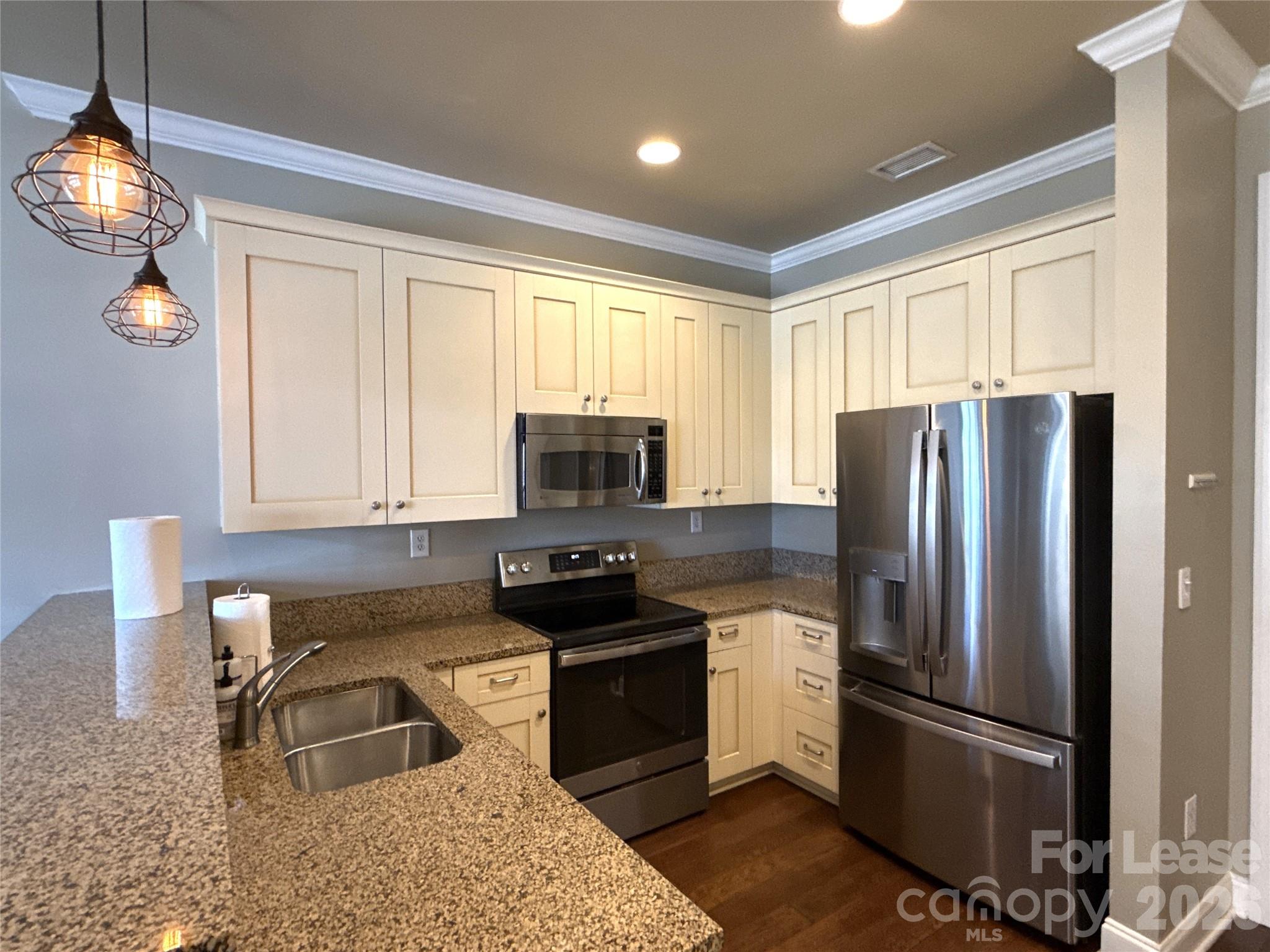 230 South Tryon Street, Unit 1002 Charlotte, NC 28202 - Photo 5 of 19 a kitchen with granite countertop a refrigerator stove and sink
