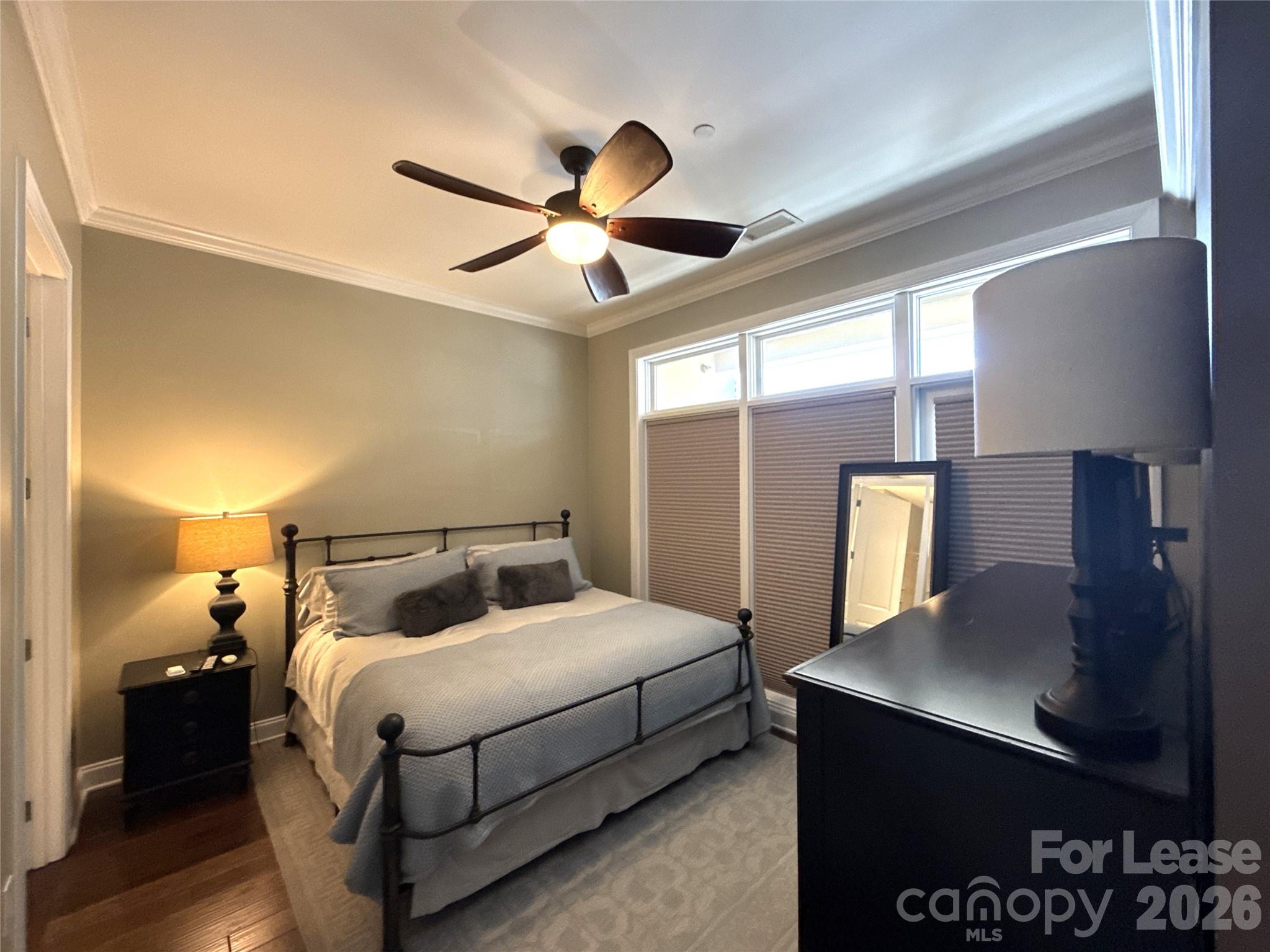 230 South Tryon Street, Unit 1002 Charlotte, NC 28202 - Photo 8 of 19 a bedroom with a bed and a dresser with a potted plant