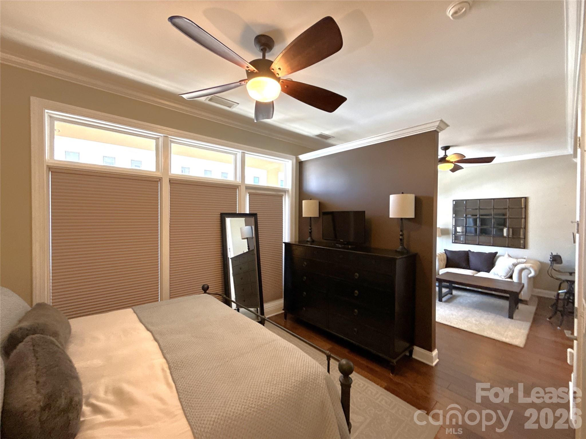 230 South Tryon Street, Unit 1002 Charlotte, NC 28202 - Photo 9 of 19 a bedroom with a bed and a chandelier