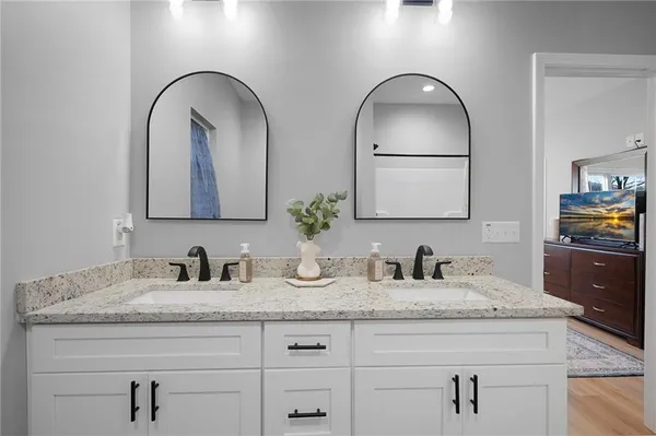 a bathroom with double vanity sink and two mirror