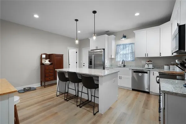 a kitchen with a refrigerator a sink and white cabinets