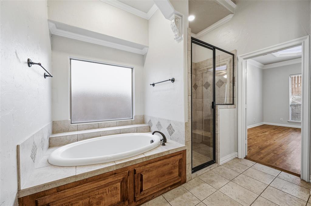 620 Highview Lane Hurst, TX 76054 - Photo 23 of 40 Built-in soaking tub with a tiled surround and wood-finish cabinetry