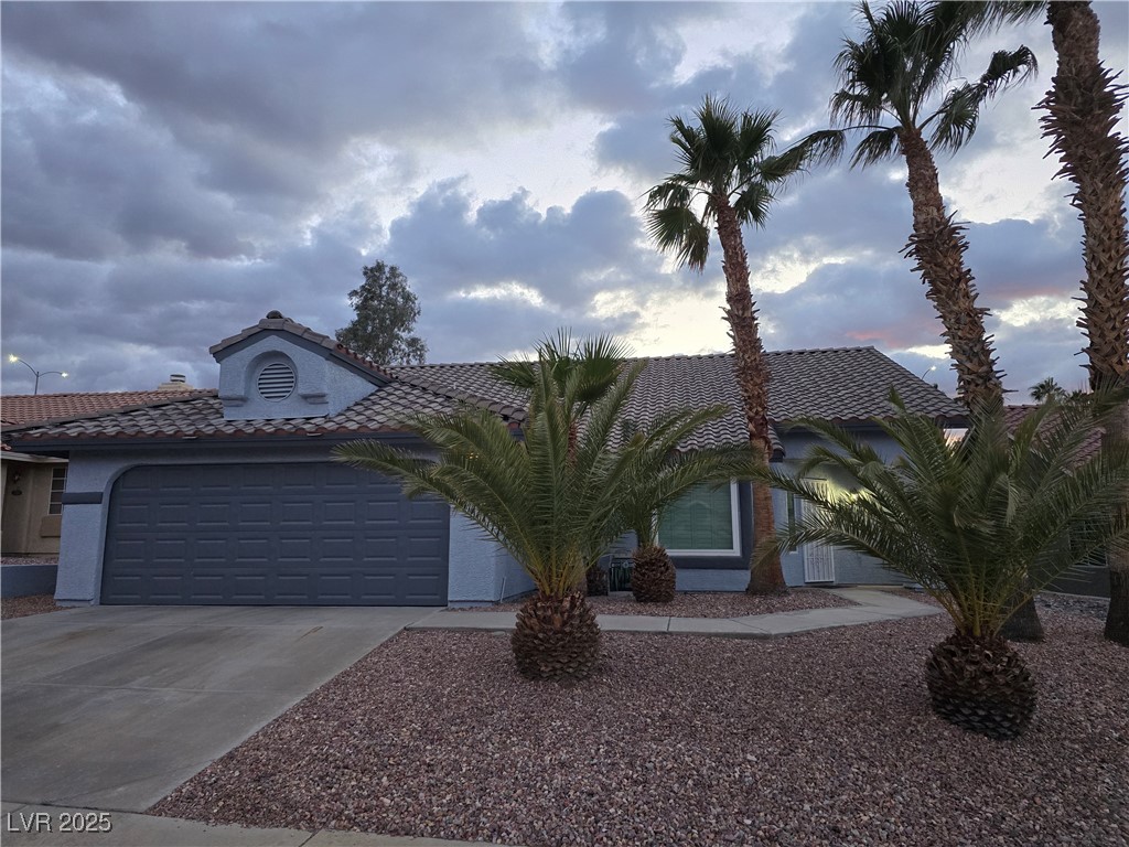 853 Rusty Anchor Way Henderson, NV 89002 - Photo 74 of 76 View of front of house with a tile roof, concrete driveway, stucco siding, and an attached garage