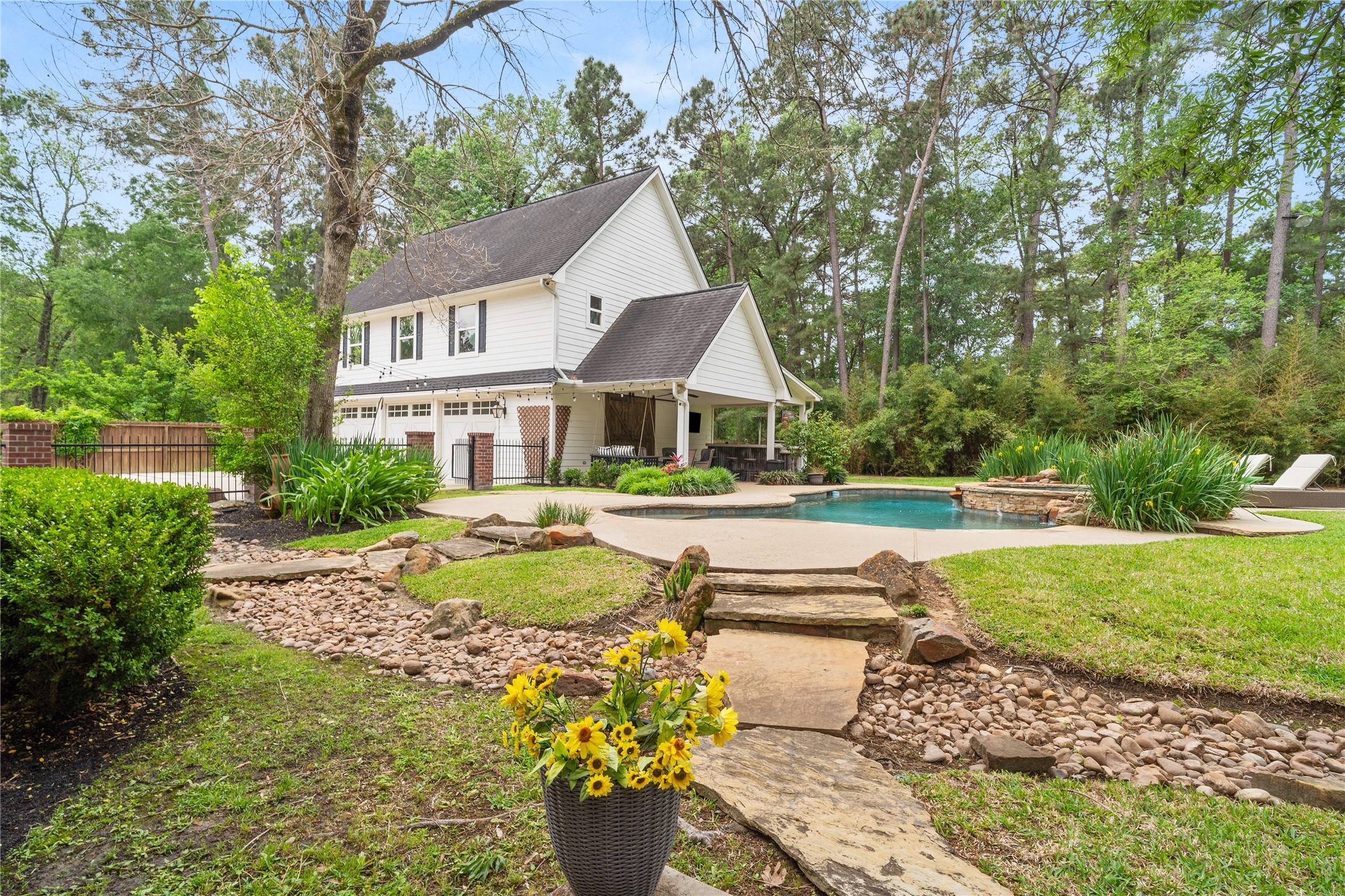 36 Wind River Drive Conroe, TX 77384 - Photo 15 of 45 A stone pathway leads to the pool area, providing a serene outdoor retreat.