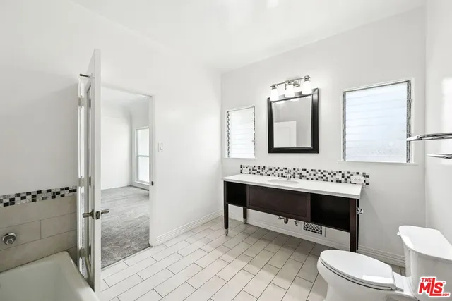 a bathroom with a sink a toilet and mirror