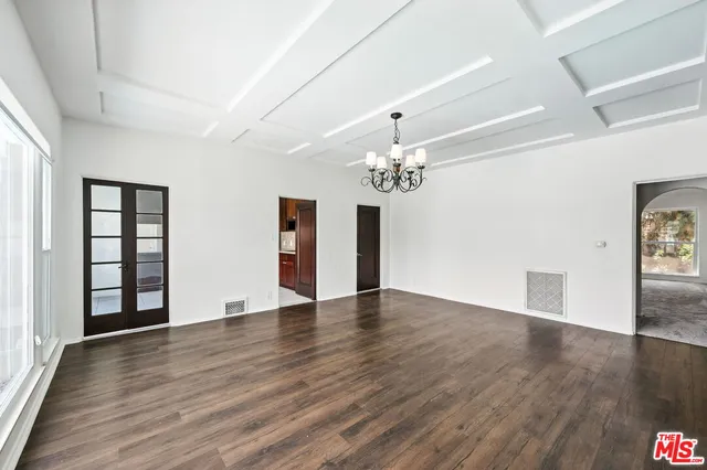 a view of an empty room with wooden floor and potted plant