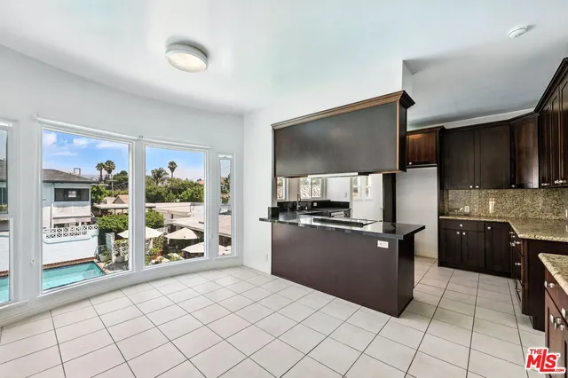 a kitchen with granite countertop a refrigerator and a stove top oven