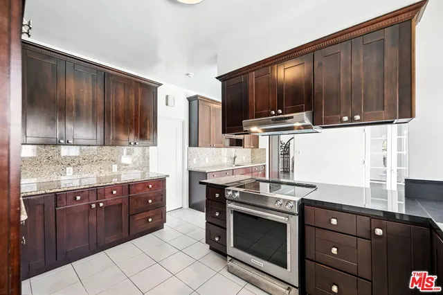 a kitchen with stainless steel appliances granite countertop wooden cabinets and a stove top oven