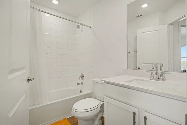 a bathroom with a sink toilet vanity and shower