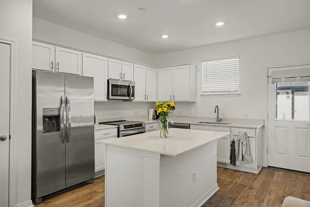 a kitchen with a sink stainless steel appliances and cabinets