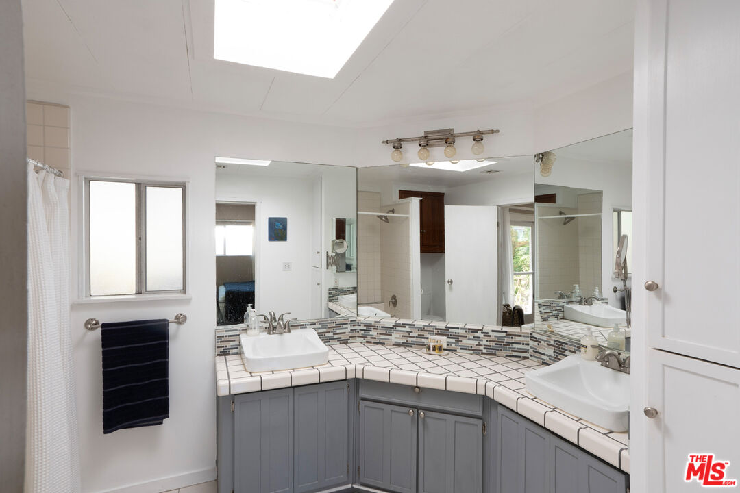 1183 Aztec Topanga, CA 90290 - Photo 32 of 68 a bathroom with a sink and a mirror