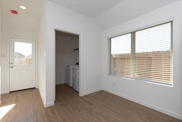 a view of a room with wooden floor and windows