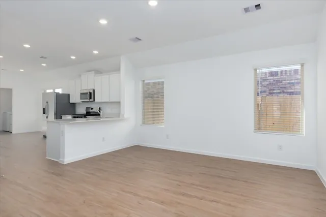 a view of kitchen with stainless steel appliances refrigerator oven and cabinets
