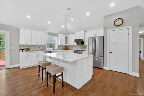 a kitchen with white cabinets and stainless steel appliances