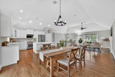 a view of a dining room and livingroom with furniture wooden floor a chandelier