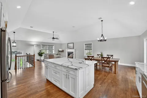 a view of a dining room and livingroom with furniture wooden floor a chandelier