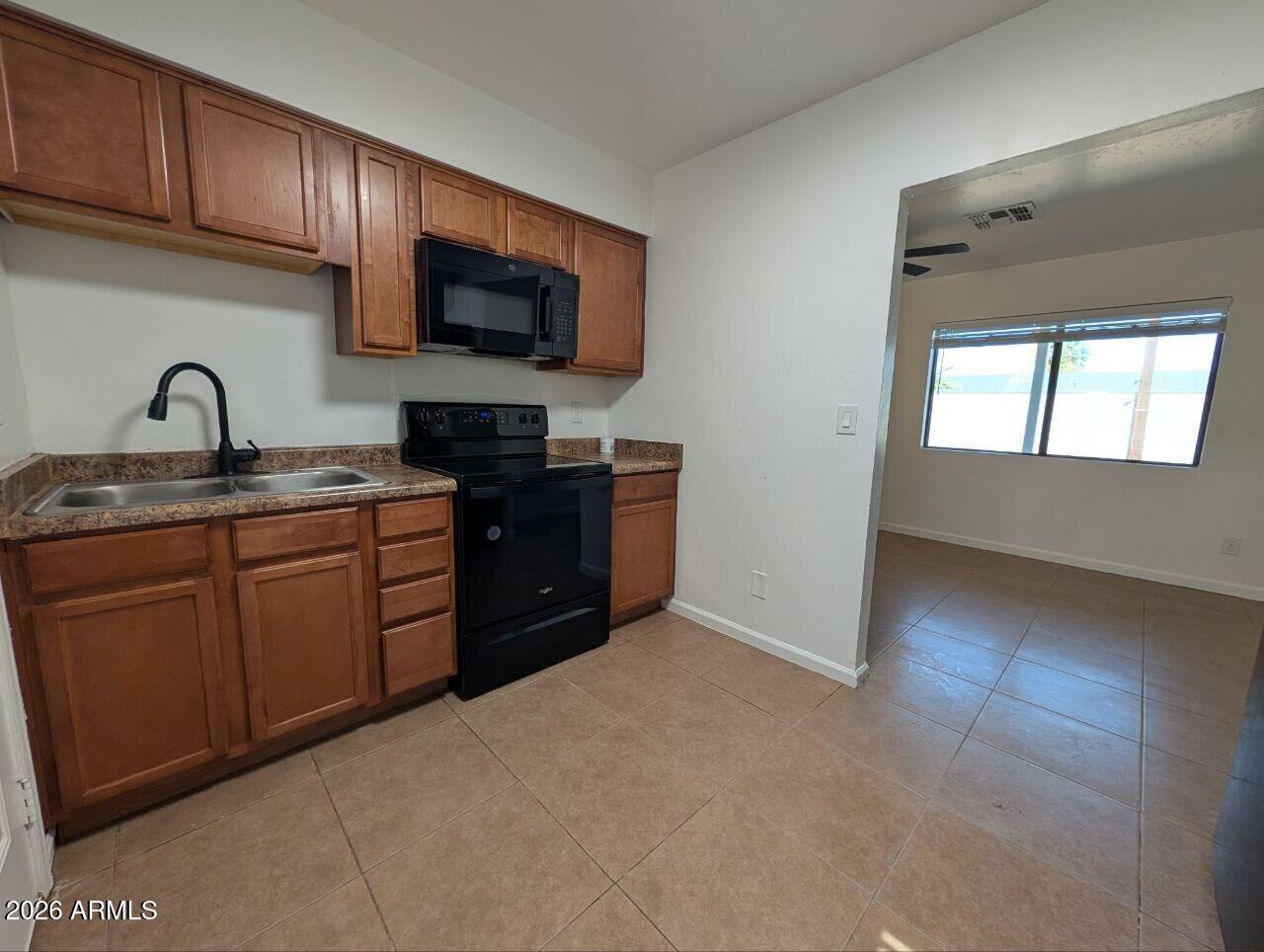 9602 North 18th Avenue Phoenix, AZ 85021 - Photo 12 of 18 a kitchen with stainless steel appliances granite countertop a stove a sink dishwasher and a microwave oven with cabinets