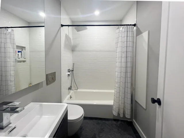 a bathroom with a bathtub shower sink and toilet