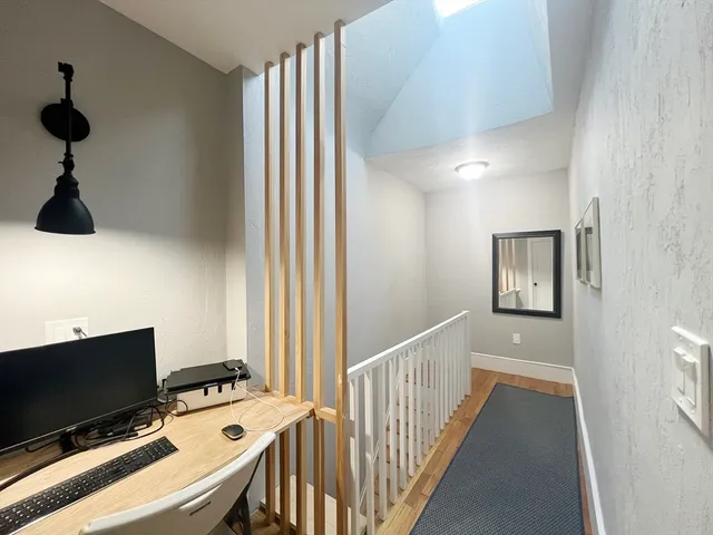 a view of a hallway to a livingroom with furniture