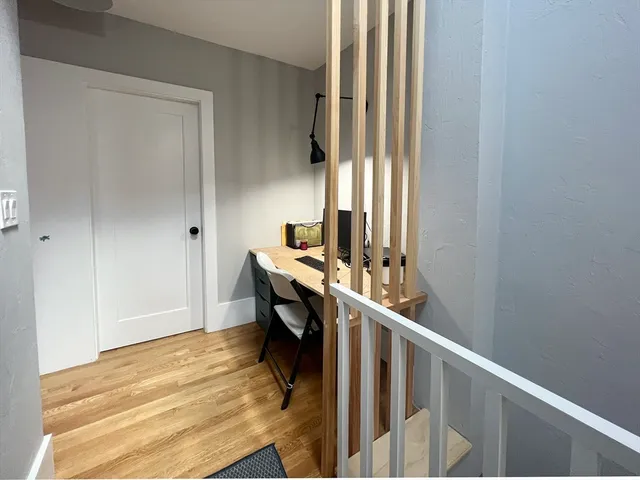 a view of a hallway with wooden floor and stairs