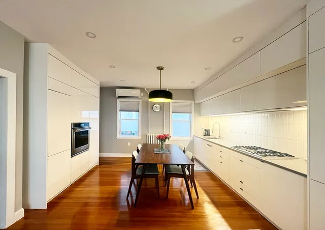 a dining room with furniture a chandelier and wooden floor