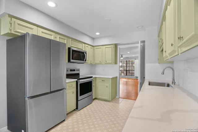 a kitchen with stainless steel appliances granite countertop a refrigerator stove and sink