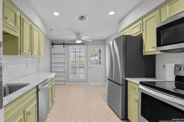 a kitchen with stainless steel appliances a refrigerator and a stove top oven