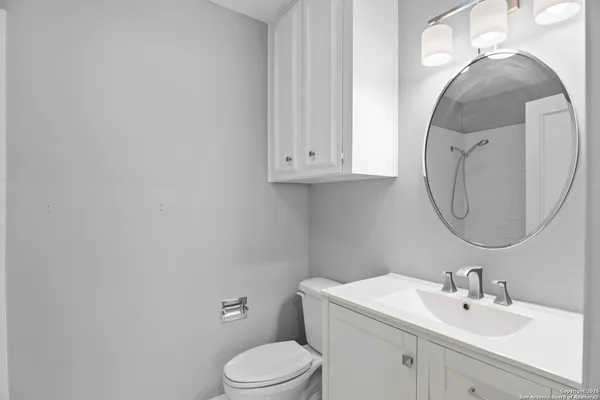 a bathroom with a toilet sink and mirror