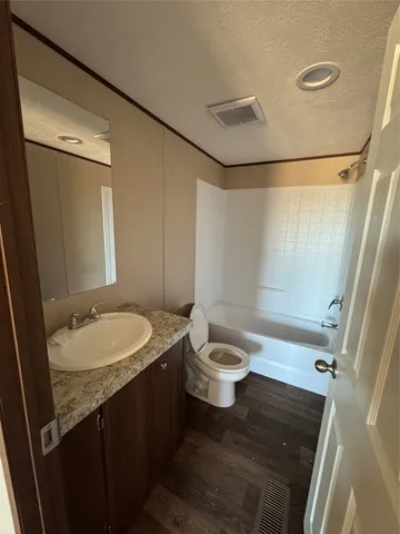 a bathroom with a granite countertop sink toilet and shower