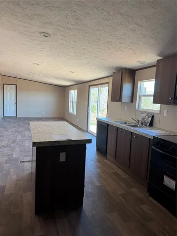 a kitchen with a sink a microwave a dining table and chairs