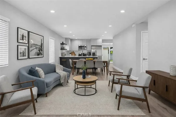 a kitchen with a dining table chairs and wooden floor