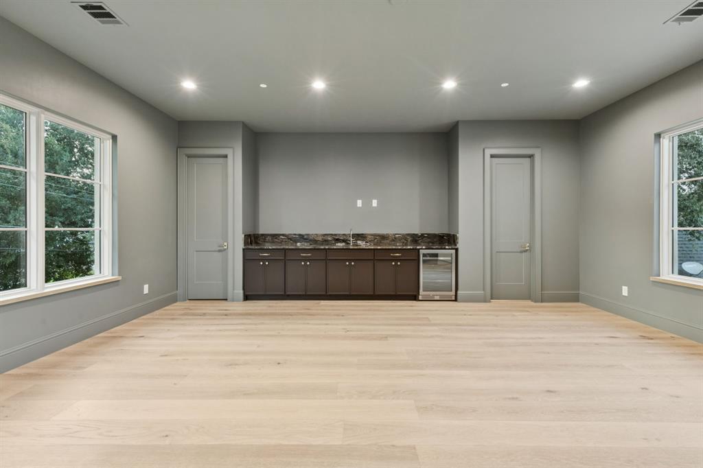 11815 Jamestown Road Dallas, TX 75230 - Photo 24 of 39 a large white kitchen with kitchen island a sink stainless steel appliances and cabinets