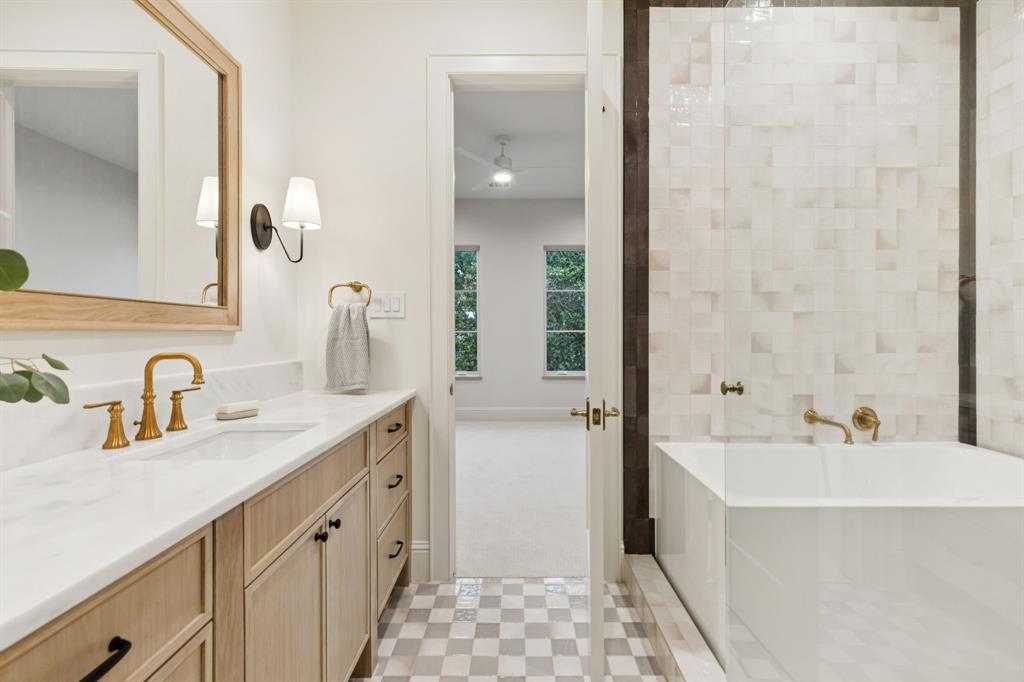 11815 Jamestown Road Dallas, TX 75230 - Photo 25 of 39 a bathroom with a double vanity sink a mirror and a bathtub