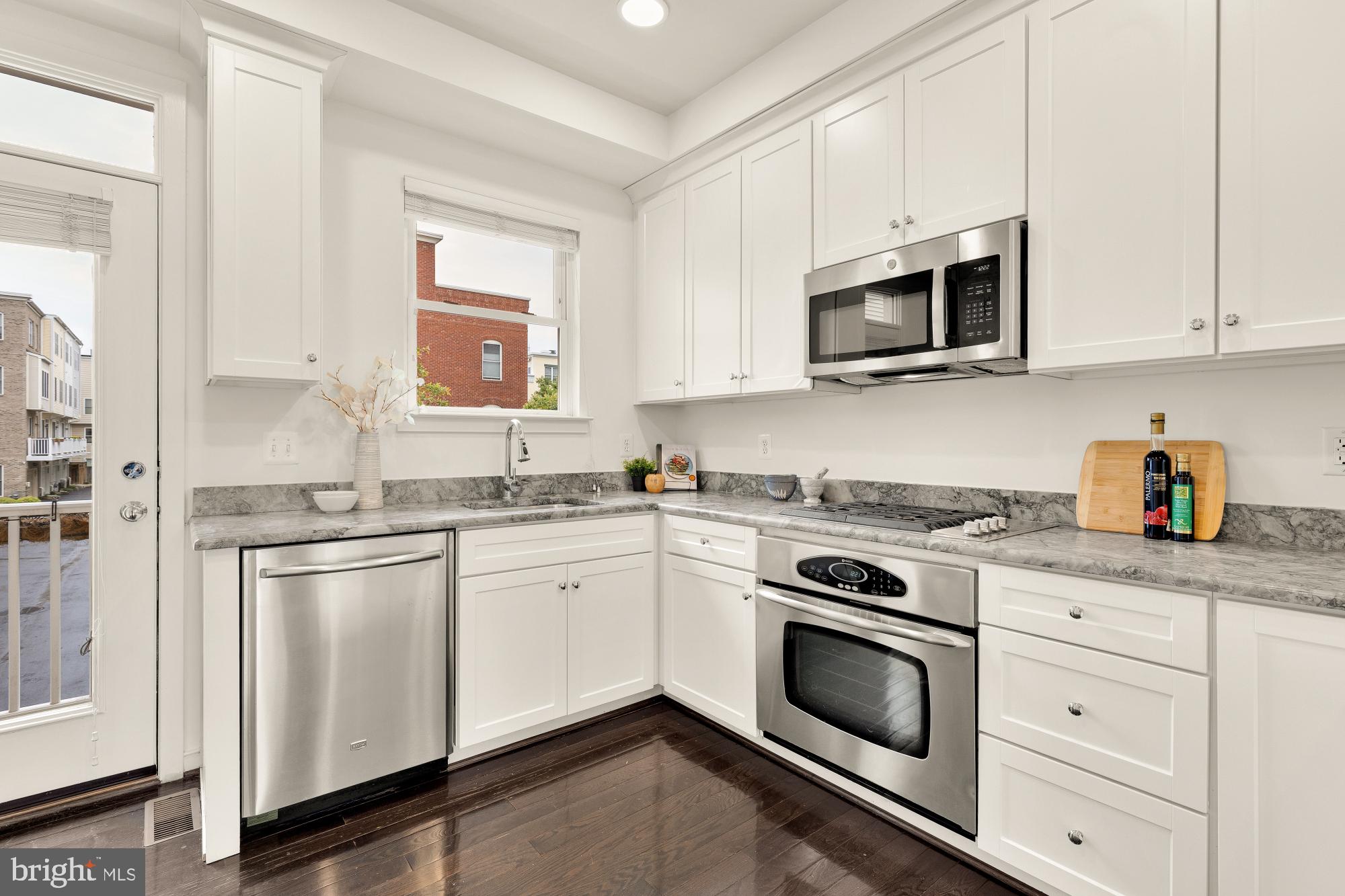 906 3rd Street Southeast Washington, DC 20003 - Photo 4 of 14 a kitchen with stainless steel appliances granite countertop white cabinets a sink stove and microwave