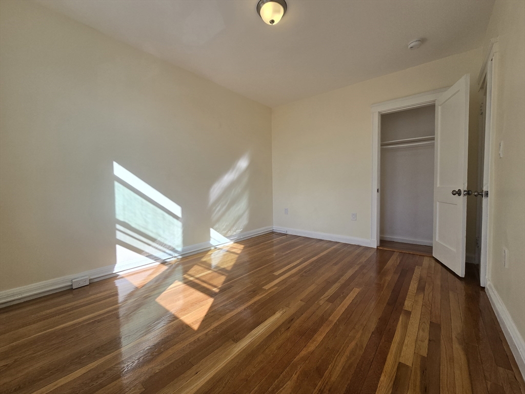 183 Kent Street, Unit 5 Brookline, MA 02446 - Photo 6 of 9 a view of empty room with wooden floor