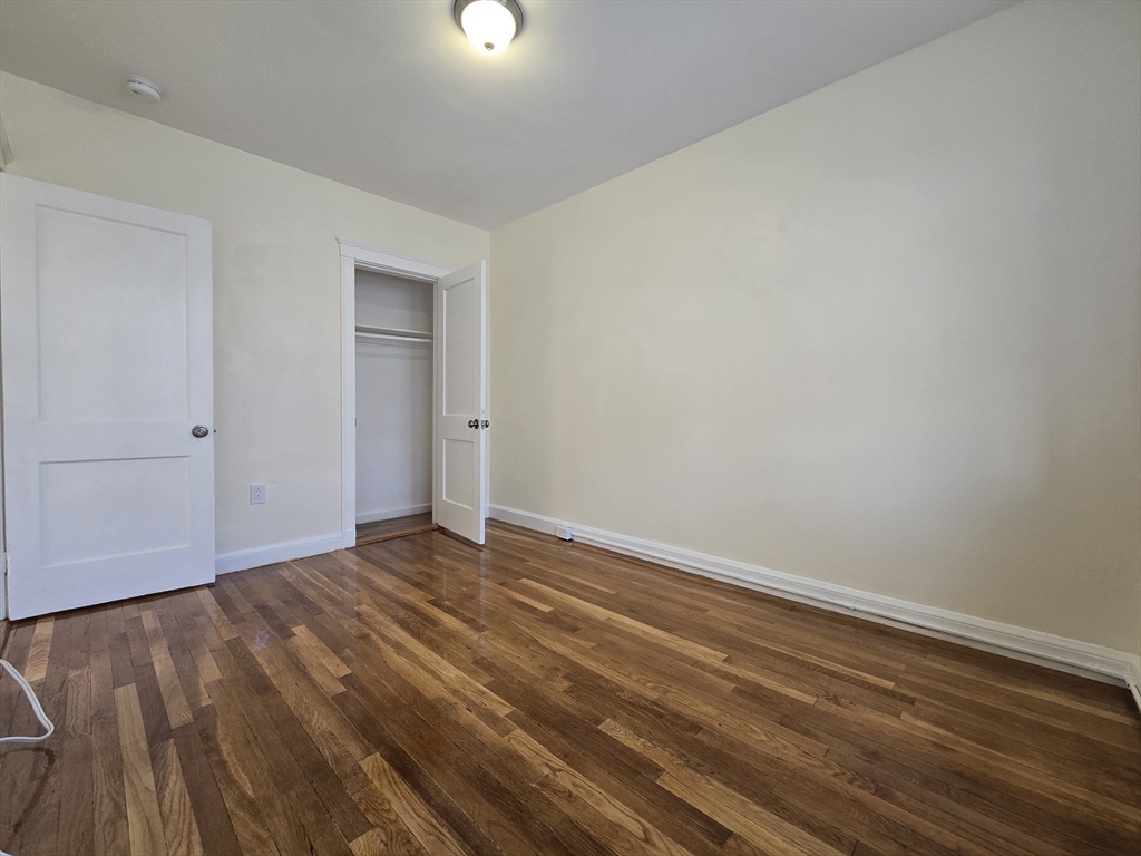 183 Kent Street, Unit 5 Brookline, MA 02446 - Photo 7 of 9 a view of an empty room with wooden floor