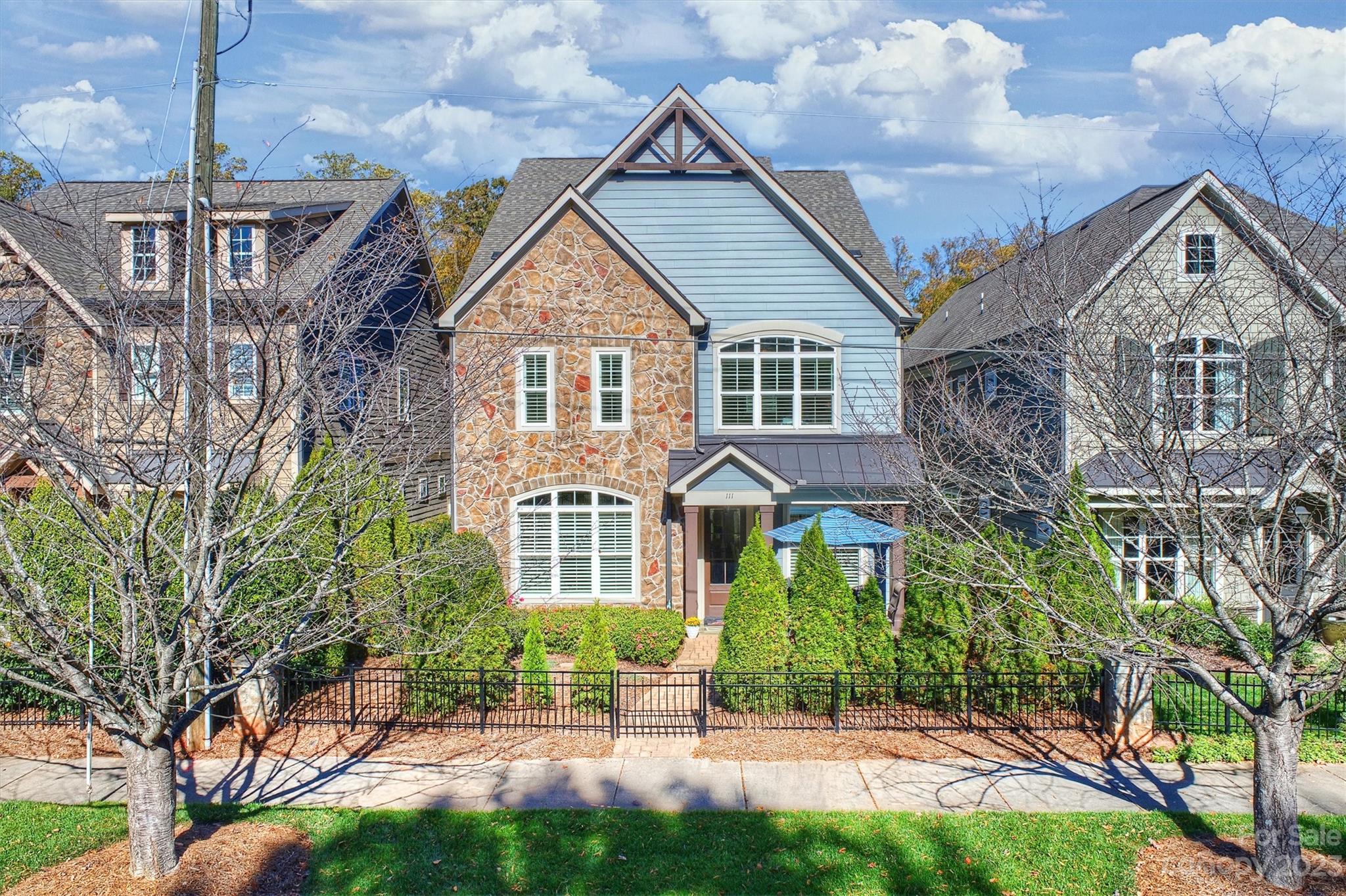 a front view of a house with a yard and potted plants