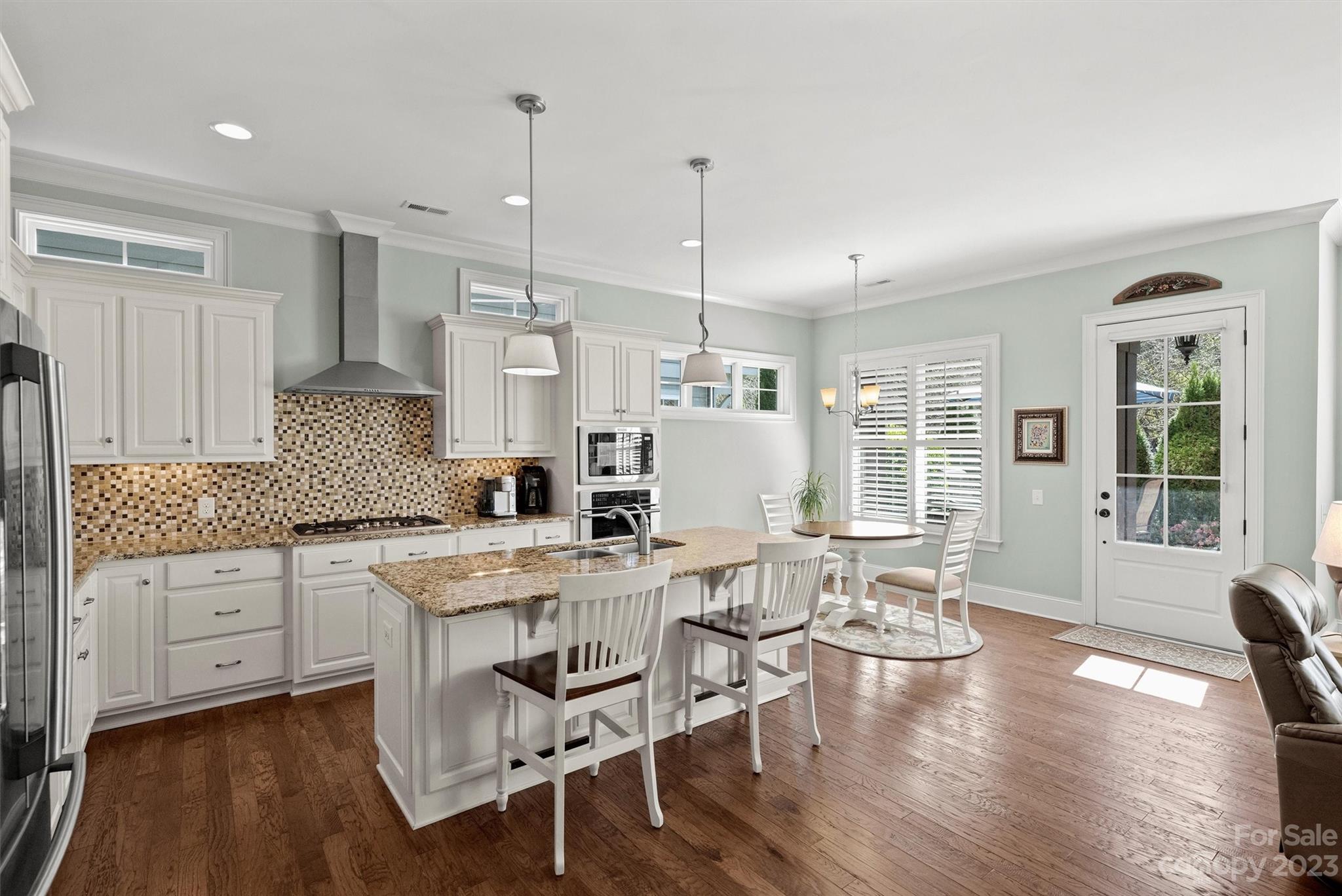 111 Boyce Road Charlotte, NC 28211 - Photo 11 of 38 a kitchen with stainless steel appliances granite countertop a stove a refrigerator a kitchen island with a dining table and chairs