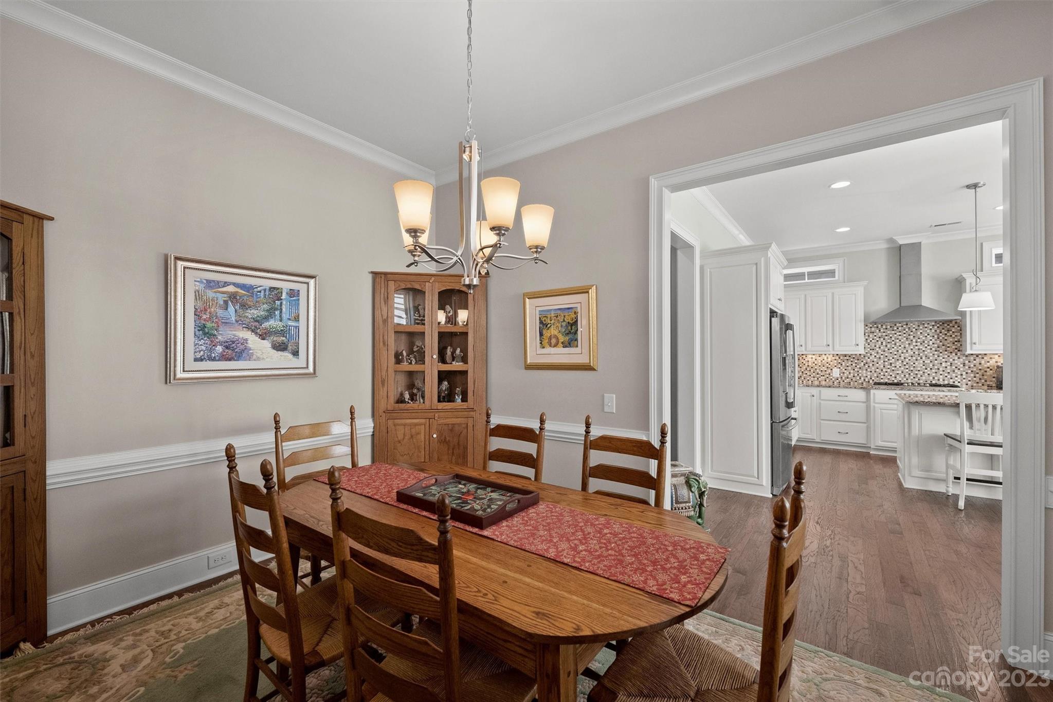 111 Boyce Road Charlotte, NC 28211 - Photo 17 of 38 a view of a dining room with furniture wooden floor and a chandelier