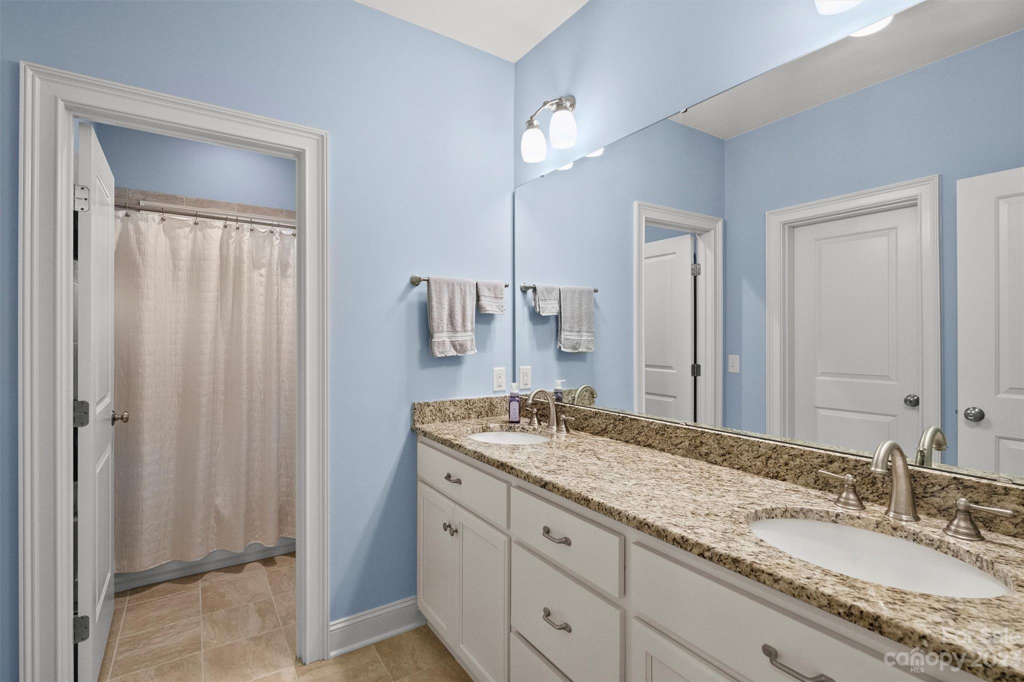 111 Boyce Road Charlotte, NC 28211 - Photo 21 of 38 a bathroom with a granite countertop sink and a mirror
