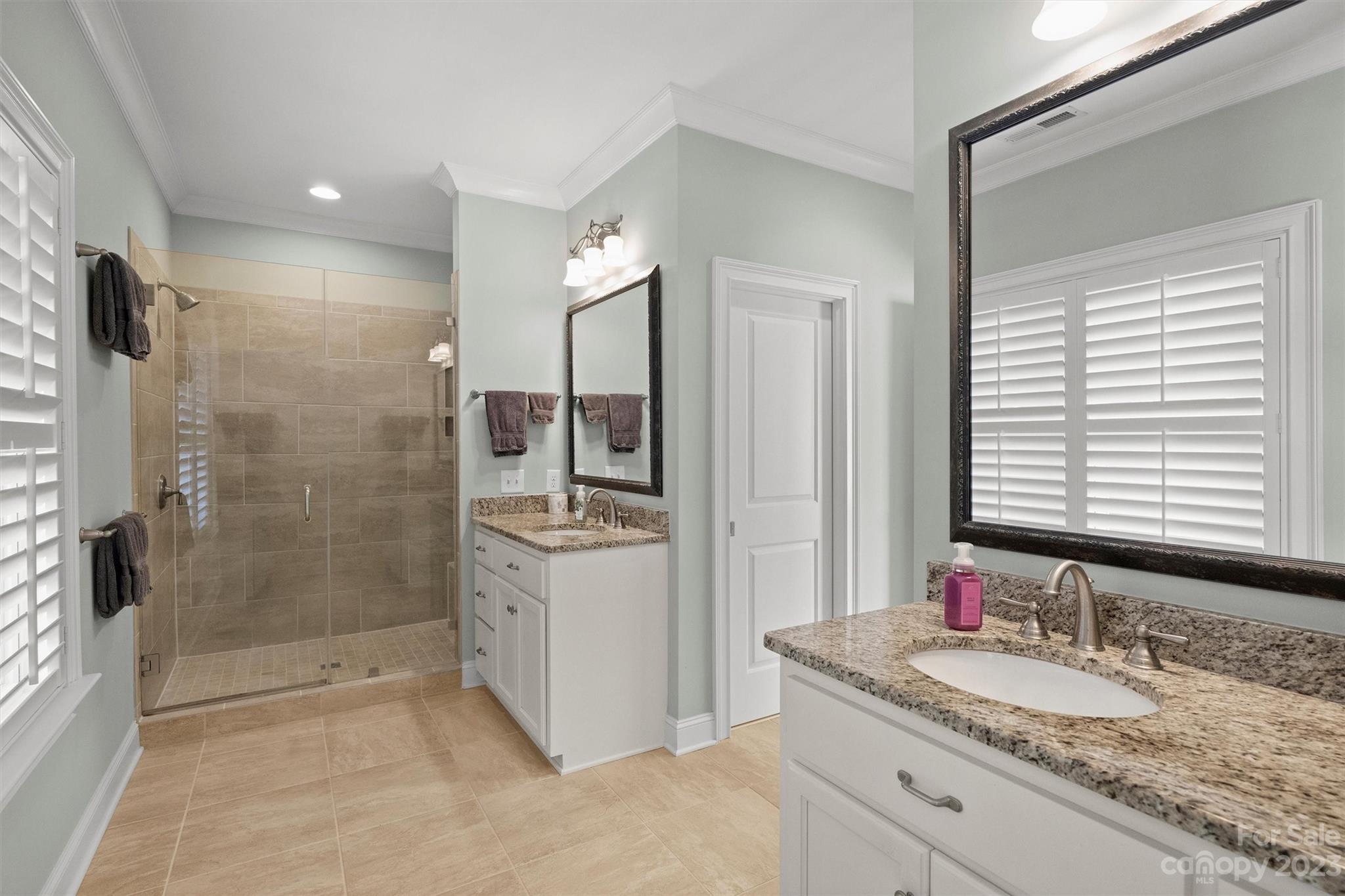 111 Boyce Road Charlotte, NC 28211 - Photo 27 of 38 a bathroom with a granite countertop sink a mirror and a shower