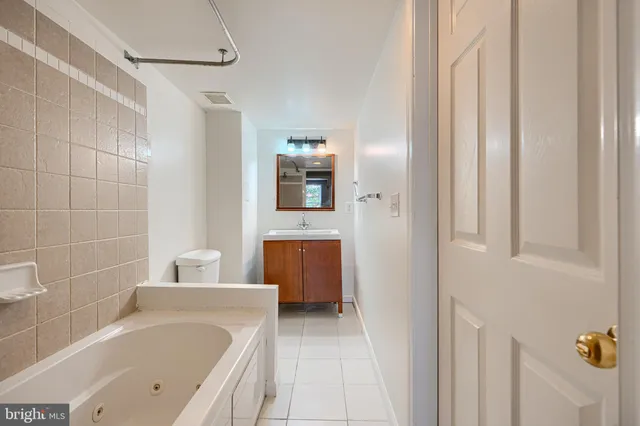 a bathroom with a tub sink and mirror