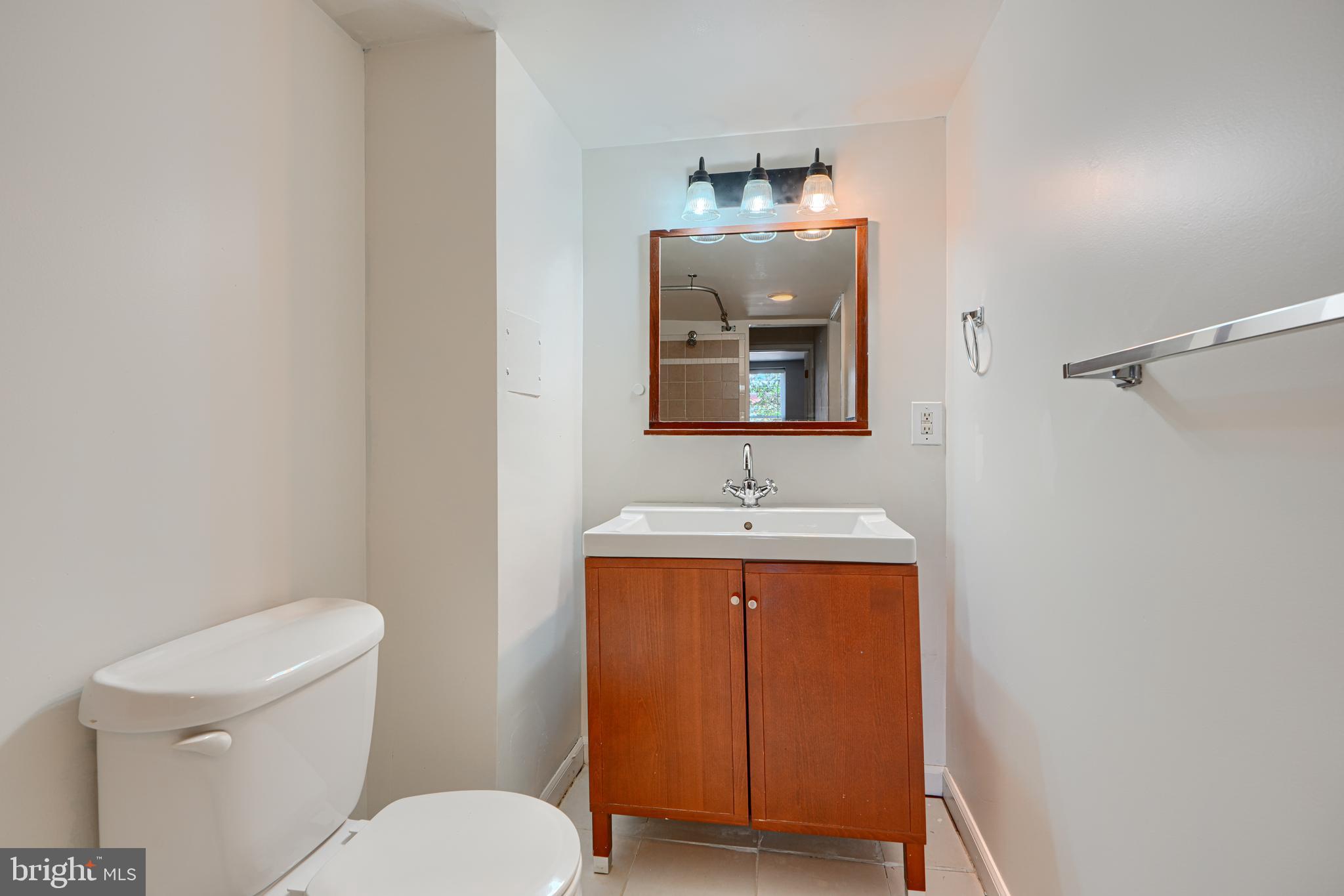 2519 Fleet Street Baltimore, MD 21224 - Photo 16 of 31 a bathroom with a toilet a sink and mirror