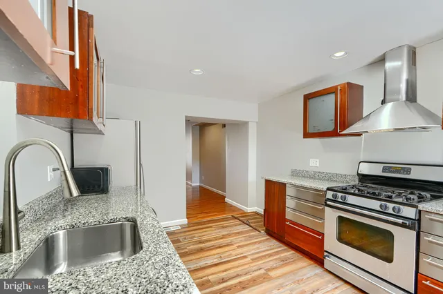 a kitchen with stainless steel appliances granite countertop a sink and a stove top oven