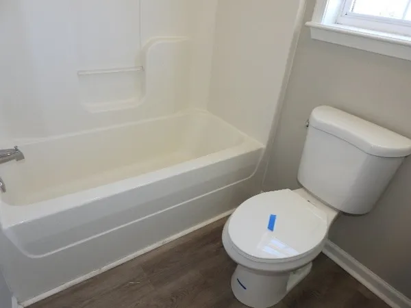 a white toilet sitting next to a bath tub