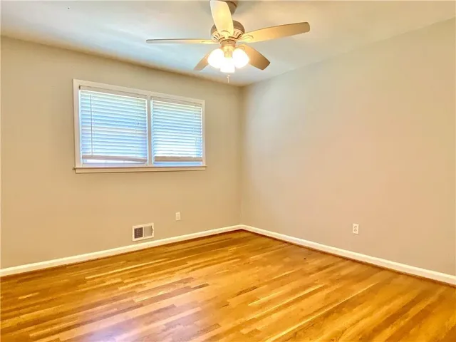 a view of a room that has a window and wooden floor