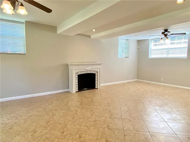 an empty room with windows and fireplace