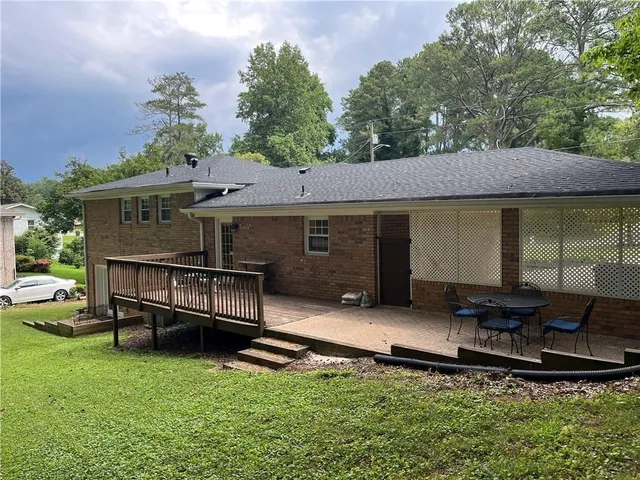 an outdoor view of house with backyard and furniture